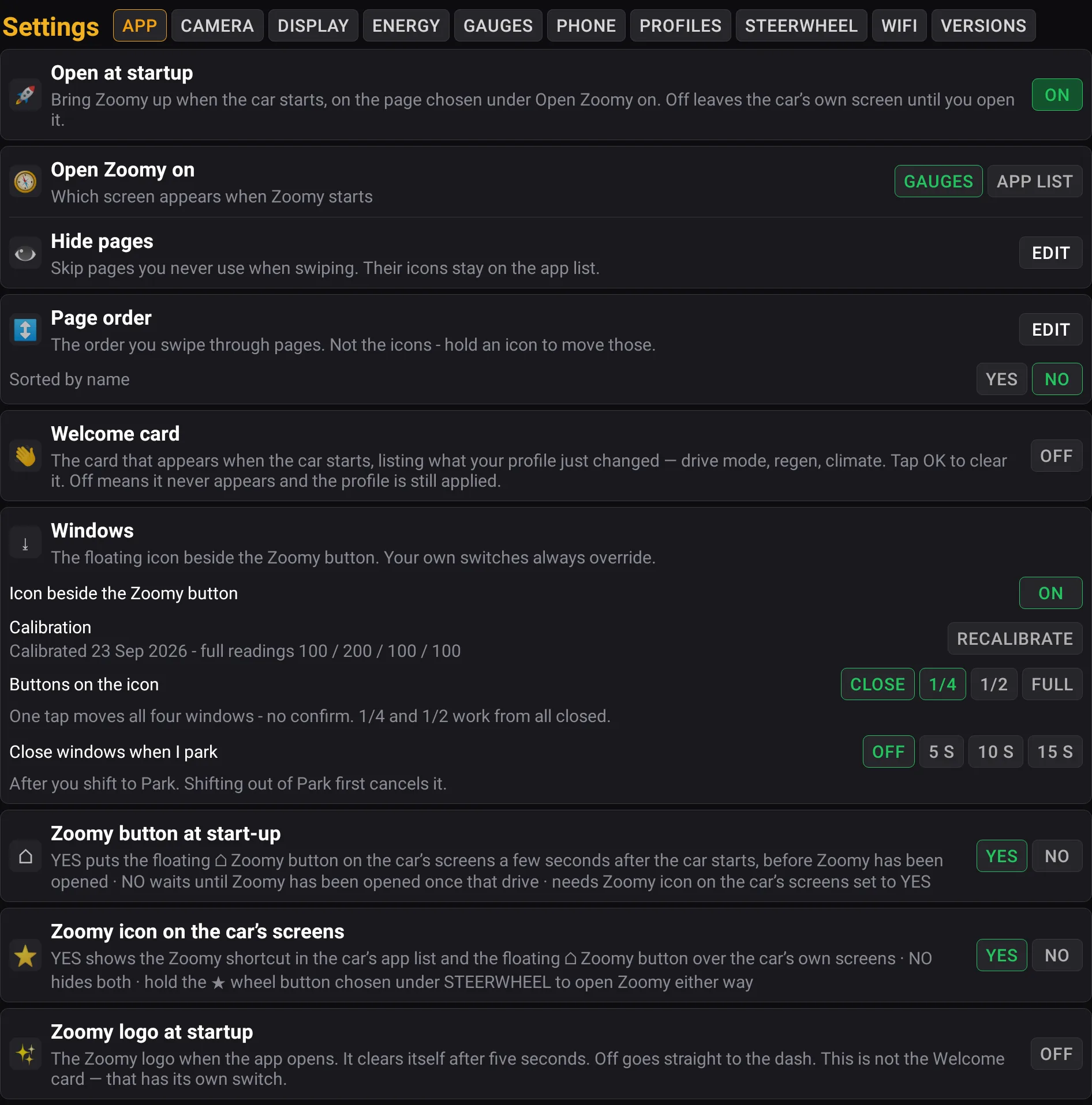 The Settings page with its ten tabs along the top — App, Camera, Display, Energy, Gauges, Phone, Profiles, Steerwheel, WiFi and Versions — and the App tab lit: open at startup and which screen Zoomy opens on, hide pages, page order, the welcome card, the windows icon, the Zoomy button at start-up, the Zoomy icon on the car’s screens and the logo at startup.